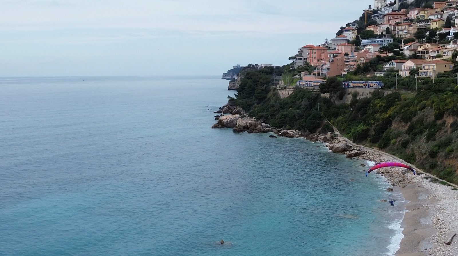 Approche de la plage du Golfe Bleu en parapente, le long de la côte de Roquebrune